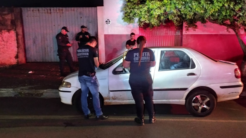 Peritos e policiais militares ao lado do carro (Foto: Leandro Holsbach)